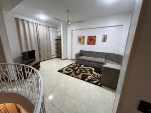 un salon avec un canapé et une télévision dans l'établissement Mohamed Home, à Jazīrat al ‘Awwāmīyah