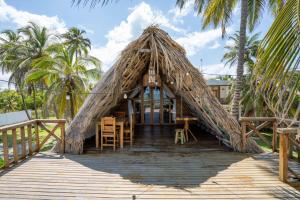 a house with a thatched roof on a boardwalk at Casa Origen Boutique en San Bernardo del Viento in San Bernardo del Viento