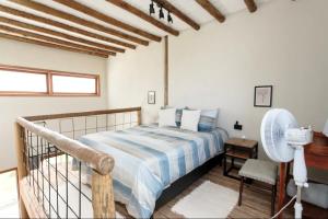 a bedroom with a bed and a desk and a fan at Esmeraldas GuestHouse in Esmeraldas