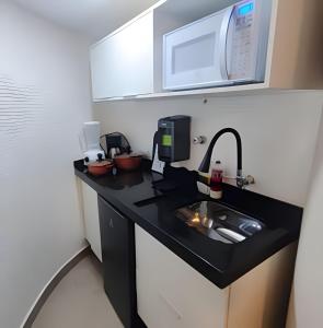 a small kitchen with a sink and a microwave at Flat GoodLar Liberdade SP Hakka Eventos in Sao Paulo