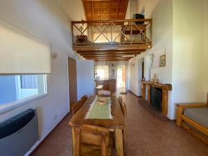 a living room with a wooden table and a balcony at CABAÑAS CON COSTA DE LAGO en CIRSE in San Carlos de Bariloche