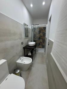 a bathroom with a white toilet and a sink at Casa Camurria in Aci Castello