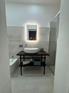 a bathroom with a sink and a mirror and a tub at Casa Camurria in Aci Castello