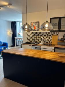a kitchen with two pendant lights above a counter at Indigo Apartment in Kassel