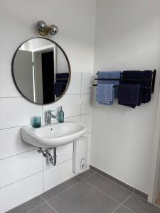 a bathroom with a sink and a mirror at Indigo Apartment in Kassel