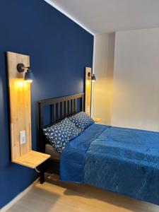 a blue bedroom with a bed and a blue wall at Indigo Apartment in Kassel