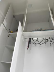 a white room with a bed and shelves at Flat no coração de Guarapari,150 metros da praia com vista encantadora in Guarapari