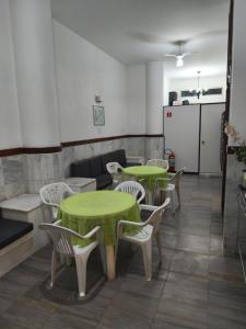 Cette chambre dispose de tables, de chaises et d'un réfrigérateur. dans l'établissement KitNet confortável com ótima localização no Cento de Guarapari, à Guarapari