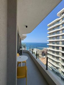 a balcony with a table and chairs and a view of the ocean at Driton`s Apartments in Shëngjin