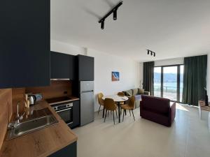 a kitchen and living room with a table and chairs at Driton`s Apartments in Shëngjin