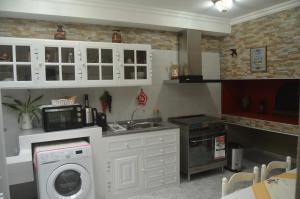 una cocina con lavadora y microondas en Vista dos Encantos, en Machico
