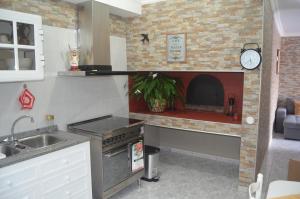 cocina con chimenea de ladrillo en Vista dos Encantos, en Machico 7 fotos más