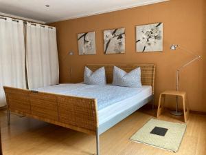 a bedroom with a wicker bed with four pictures on the wall at Ferienwohnung Hempfling in Rostock