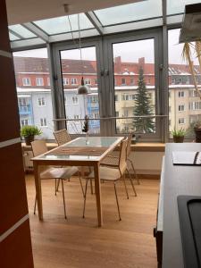 a dining table and chairs in a room with a large window at Ferienwohnung Hempfling in Rostock