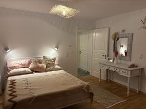 a bedroom with a bed and a table and a mirror at Villa Xalupi - Design-Villa mit Pool und Meerblick in Paleokastritsa +127 photos