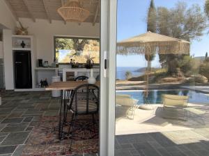 a kitchen and dining room with a view of the ocean at Villa Xalupi - Design-Villa mit Pool und Meerblick in Paleokastritsa