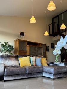 a leather couch with colorful pillows in a living room at Casa Maricarmen villa in Tacoronte