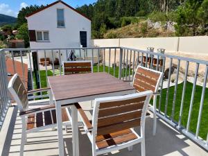 a wooden table and chairs on a balcony at Casa das Laixas in Laxe