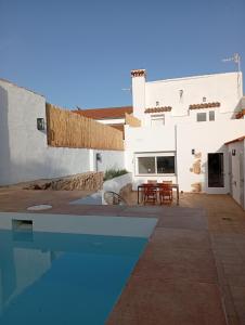 a villa with a swimming pool in front of a house at Casa Rural la Sierra del Viento in Guadalcanal