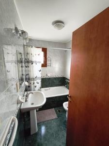 Un baño con lavabo, bañera e inodoro. en Jardín del Piltri, en El Bolsón