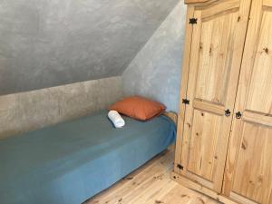 a small bed in a room with a cabinet at Brama Gór in Górki Małe