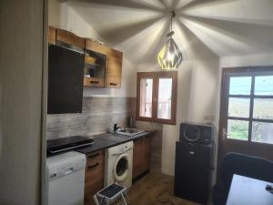 a small kitchen with a washer and dryer in it at Studio avec chambre au calme face à un champs in Castelginest