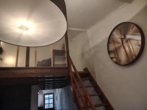 a large clock on the wall next to a staircase at Studio avec chambre au calme face à un champs in Castelginest