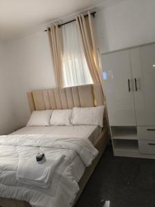 a bed in a room with a window and a cabinet at 1 or 2 Bedroom Luxury Ikeja Mini Flat Ikeja Lagos, Airport 5mins, 24 Hours power, GRA 3mins---Your Elegant Home in Ikeja in Ikeja