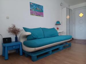 a blue couch sitting in a living room at Art room JASMINA with sea view - Bikers and pets are welcome in Starigrad-Paklenica