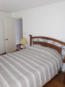 a bedroom with a large bed with a wooden headboard at Miraflores, Lima, apartamento 2 dormitorios in Lima