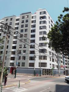 ein großes weißes Gebäude mit einer Person, die davor steht. in der Unterkunft Miraflores, Lima, apartamento 2 dormitorios in Lima + 16 Fotos