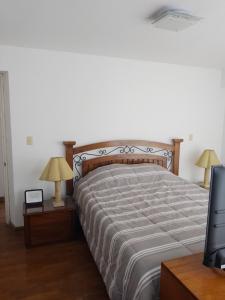 ein Schlafzimmer mit einem Bett mit zwei Lampen und einem TV in der Unterkunft Miraflores, Lima, apartamento 2 dormitorios in Lima