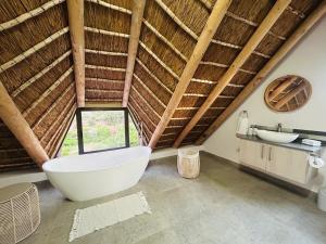 a bathroom with a large white tub and a sink at Bayview Bliss at Springerbaai Luxury Eco Villa with Ocean Views & Beach Access in Mossel Bay +58 photos