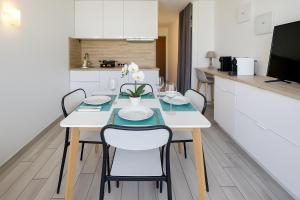 a dining room with a table and chairs in a kitchen at Mas du Tanit - Escapade en bord de mer, terrasse & soleil in Antibes +7 photos