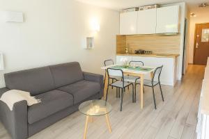 a living room with a couch and a table and a kitchen at Mas du Tanit - Escapade en bord de mer, terrasse & soleil in Antibes