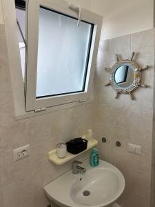 un bagno con lavandino e specchio di Vista D' Amare a Porto Potenza Picena Altre 16 foto