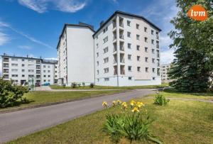 Una hilera de edificios blancos con flores amarillas en el césped. en Mai 59 Apartment, en Pärnu