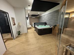a large bathroom with a tub and a shower at Élégance spa suite in Thiers