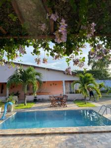a pool in front of a house with trees at Recanto do Lima in Camocim