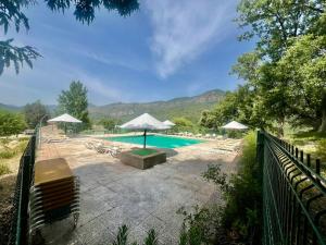 アロヨ・フリオにあるApartamentos Rurales el Chaparralのラウンジチェアとパラソル付きのスイミングプール +14枚の写真