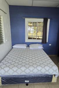 a bed in a blue room with a window at Apartamento de montaña frente al mar in La Libertad