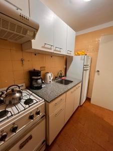 a kitchen with a stove and a refrigerator at Studio Arena y Sol - MDQ Centro in Mar del Plata