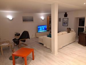 ein Wohnzimmer mit Sofa und Fernseher in der Unterkunft Peaceful house just for you! in La Ville-du-Bois