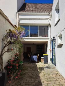 ein weißes Haus mit einem Tisch und ein paar Blumen in der Unterkunft Peaceful house just for you! in La Ville-du-Bois