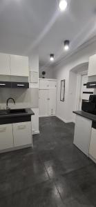 una cucina con mobili bianchi e ripiani neri di Apartament Antracyt a Wałbrzych Altre 32 foto