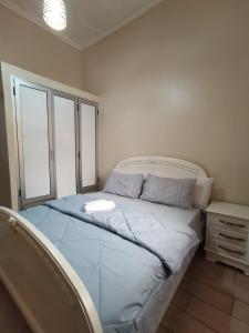 a bedroom with a bed with blue sheets and a window at Marhaba in Nador +4 photos
