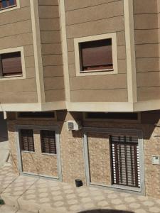 a building with two windows and a door at Marhaba in Nador +4 photos