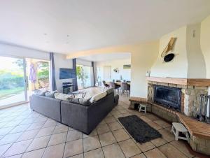 a living room with a couch and a fireplace at Appartement familial 118 m2 proche Bayonne in Hasparren