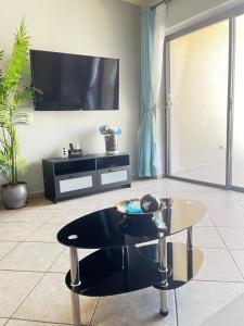 ein Wohnzimmer mit einem Couchtisch und einem Flachbild-TV in der Unterkunft Las Palomas Beach & Golf Resort in Puerto Peñasco