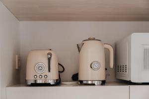 a coffee maker and a microwave on a shelf at Stella Maris- Seafront Apartment Pythagoreio in Pythagoreio